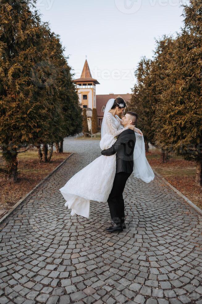 Casamento casal em uma andar dentro a outono parque. a noiva dentro uma lindo branco vestir. amor e relação conceito. noivo e noiva dentro natureza ao ar livre foto