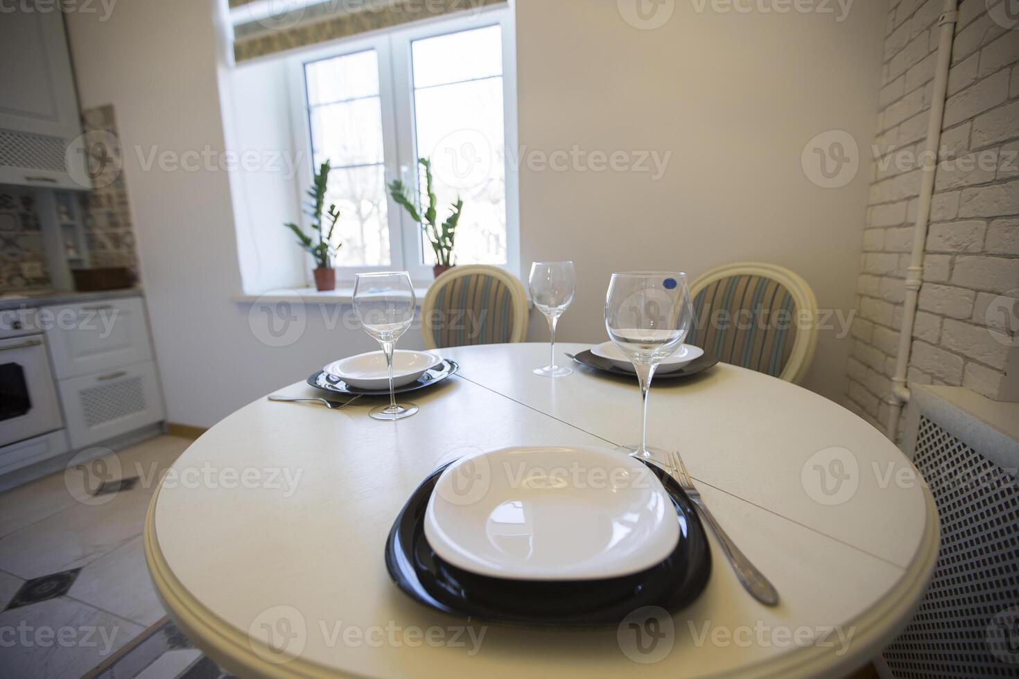 mesa com pratos e óculos em a fundo do uma pequeno cozinha foto