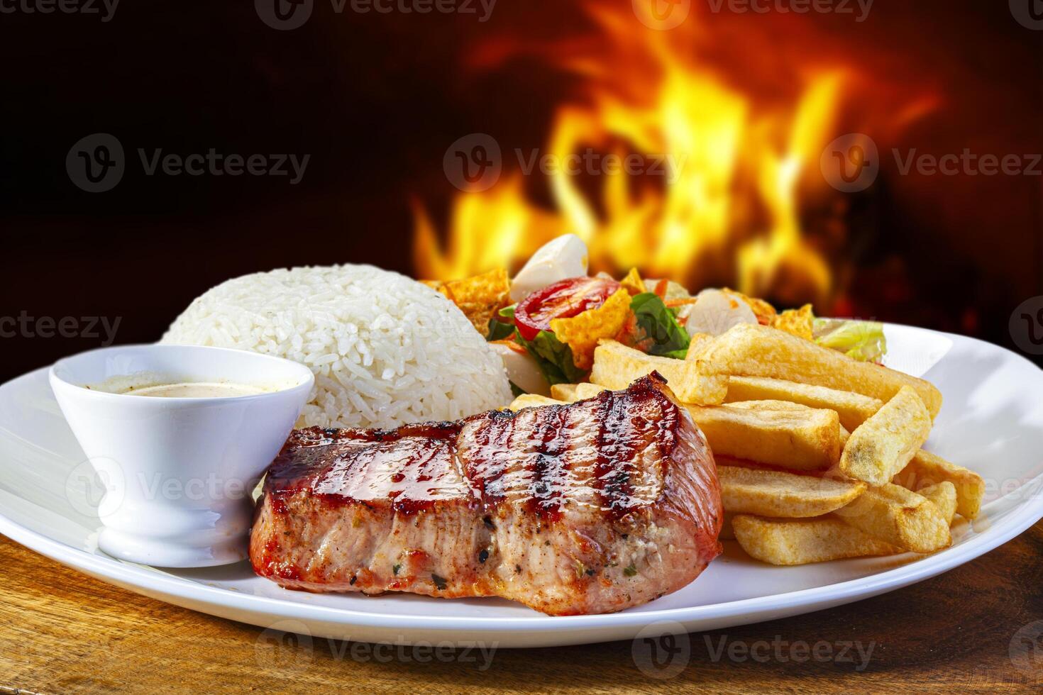 grelhado carne de porco bife com arroz, francês fritas e salada foto