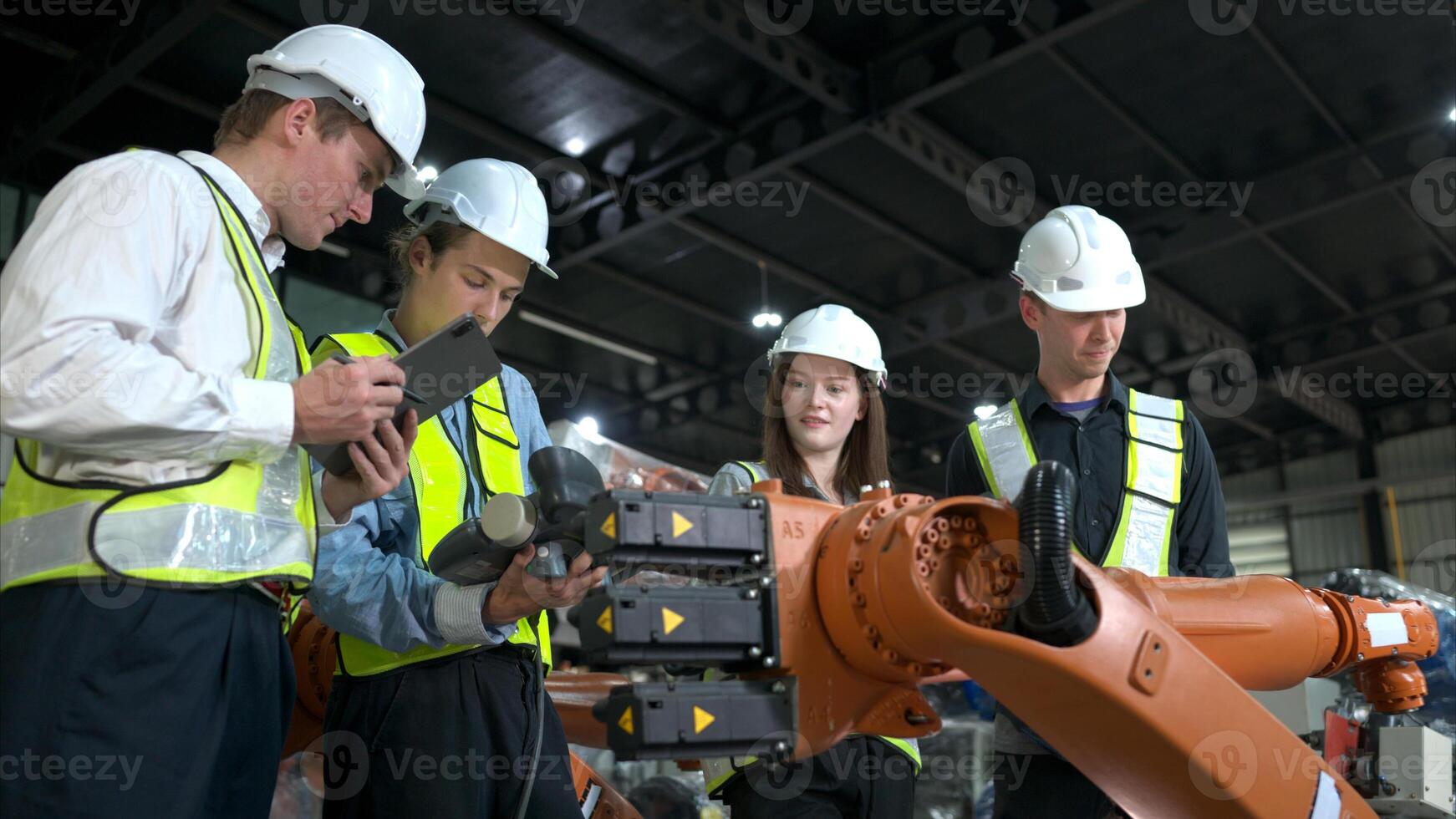 grupo do engenheiros e técnicos trabalhando juntos dentro uma robótico braço fábrica. inspecionando robô braço antes entregando para clientes foto