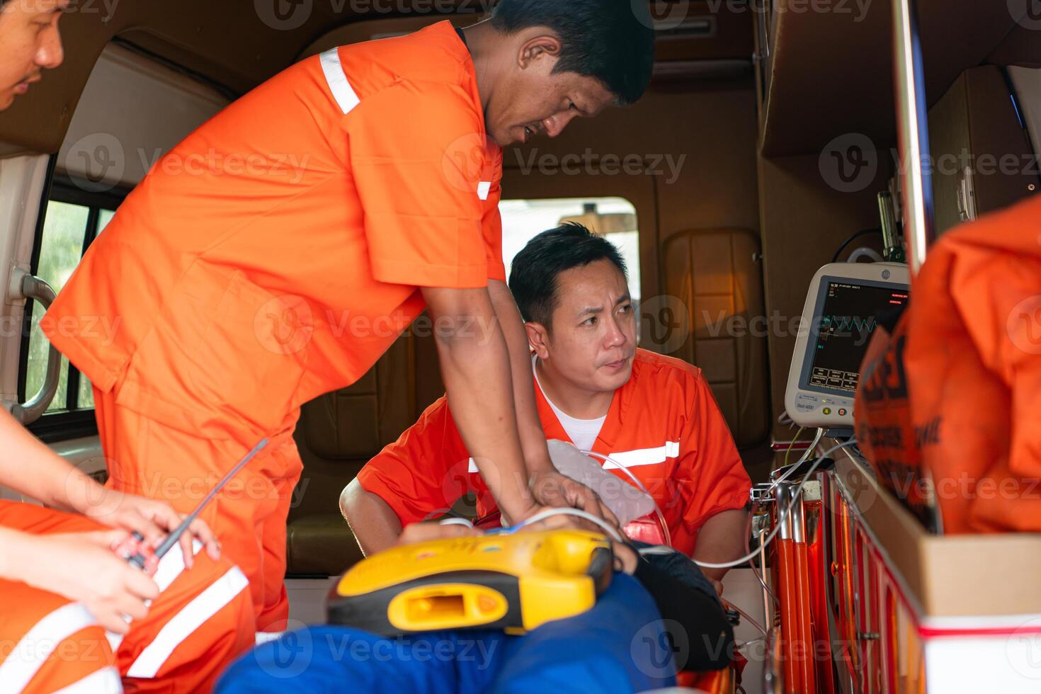 a resgate equipe é administrando cpr para uma paciente quem estava envolvido dentro a ambulância acidente. foto