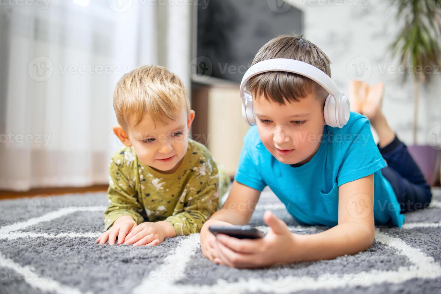 dois crianças assistindo inteligente telefone, feliz crianças usando smartphones juntos foto