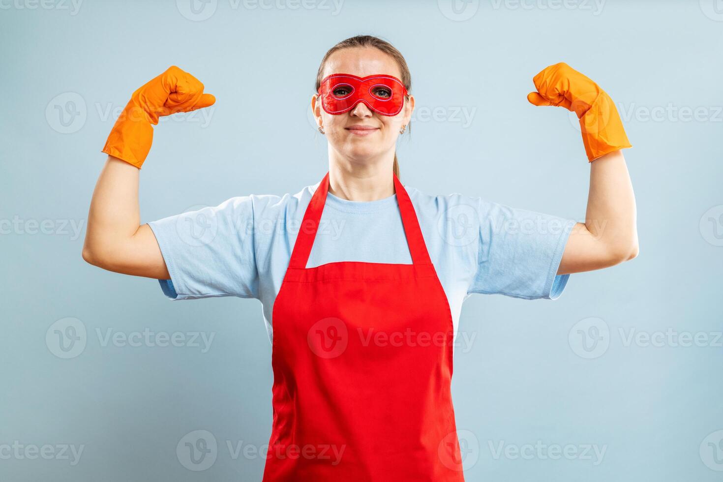 jovem confiante dona de casa dentro limpeza Super heroi traje em azul fundo foto