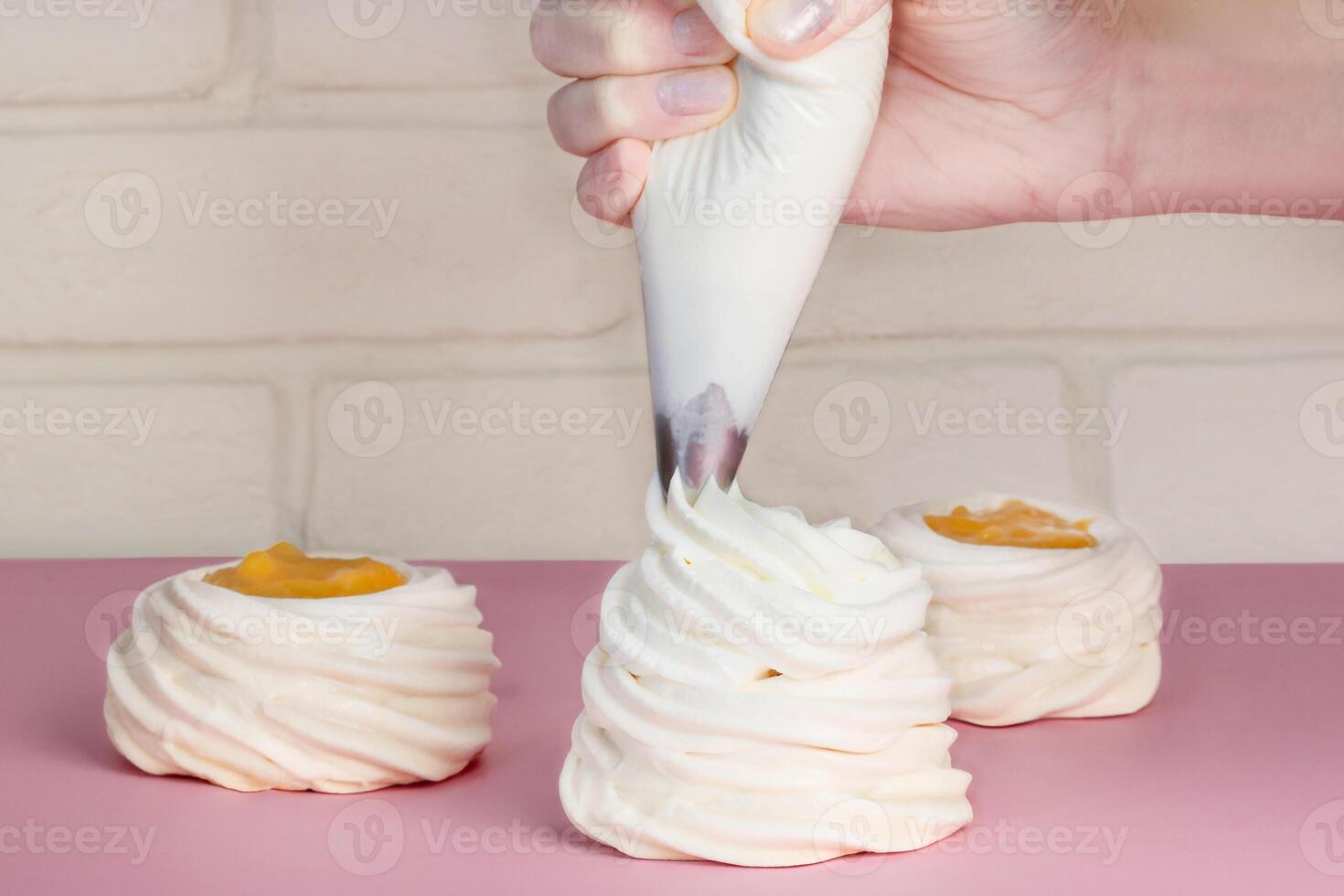 chefe de cozinha cozinhando uma Pavlova sobremesa, decora bolos com creme. fechar acima foto