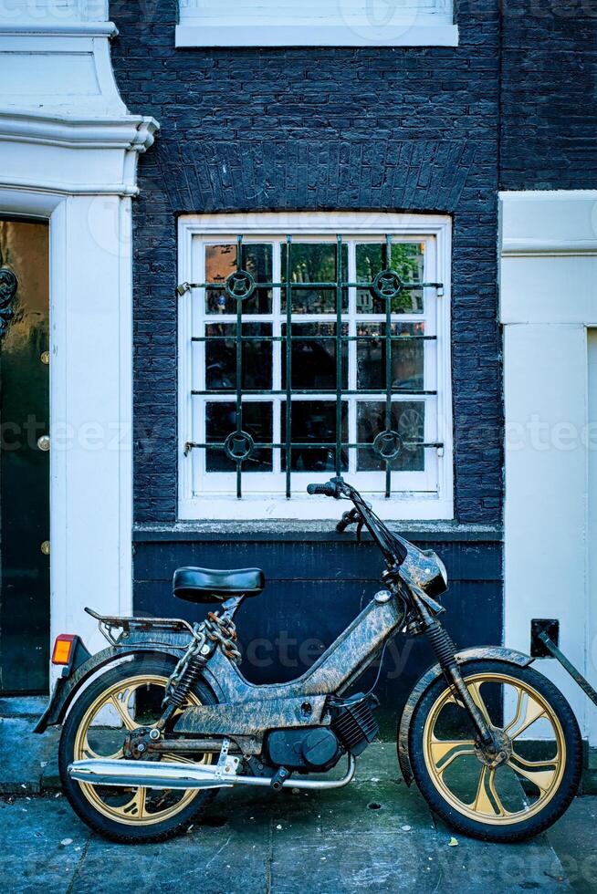 moto estacionado perto velho casa dentro amsterdam rua, foto