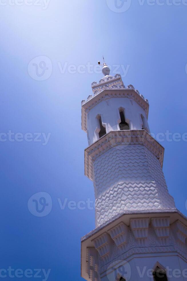 mesquita torre com azul céu fundo com luz brilhando em isto foto