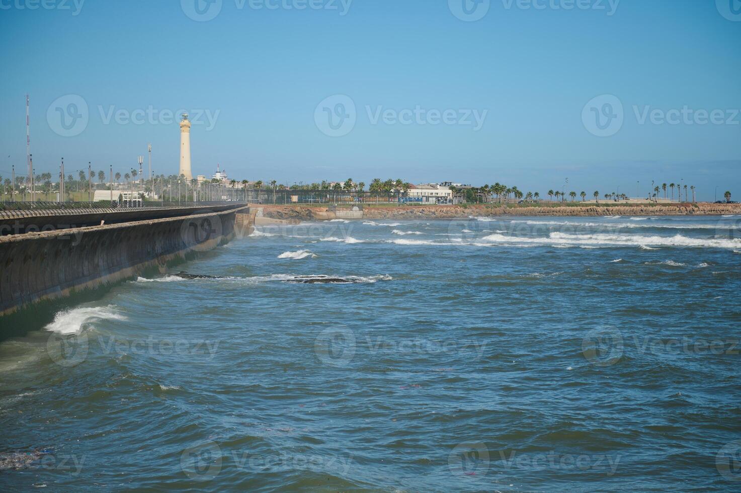 Visão do mar ondas batendo em a promontório. farol em a fundo. atlântico oceano fundo. natureza pano de fundo foto