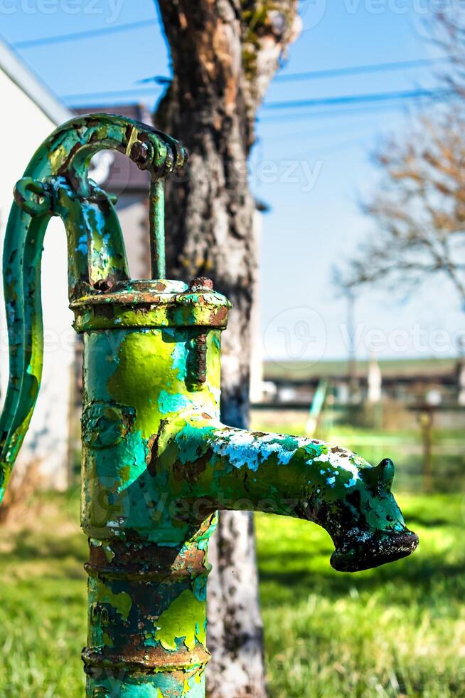 velho mão água bomba em uma bem dentro a jardim, rega e salvando água, rural ambiente foto