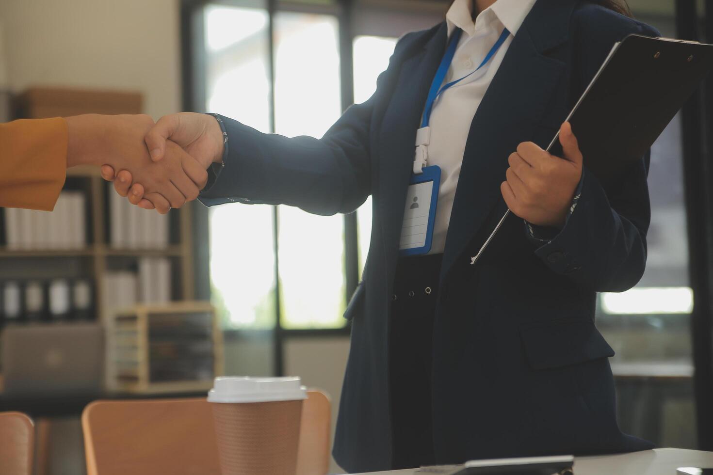 corretor de imóveis e cliente apertando as mãos depois de assinar documentos de contrato para compra de imóveis, funcionários do banco felicitam, aprovação de empréstimo hipotecário de conceito. foto