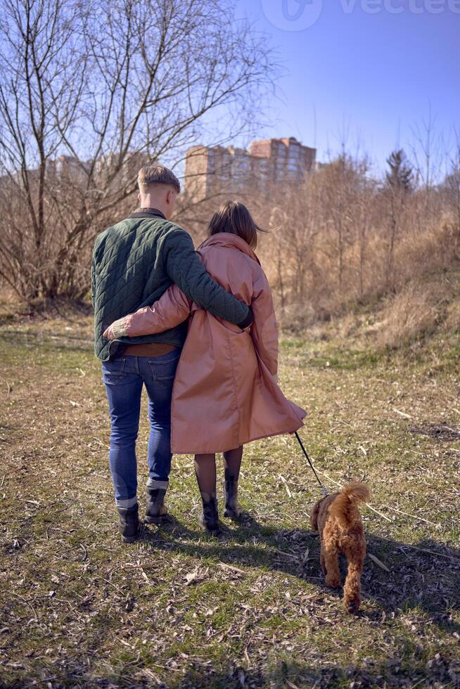uma à moda jovem casal caminhando com seus cachorro dentro natureza foto