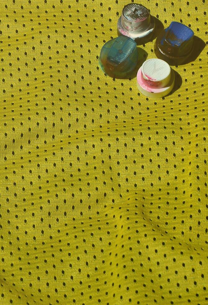 várias tampas para pulverizadores de tinta aerossol usados estão na camisa esportiva de um jogador de basquete feita de tecido de poliéster. o conceito de arte de rua juvenil, esportes ativos e estilo de vida agitado foto