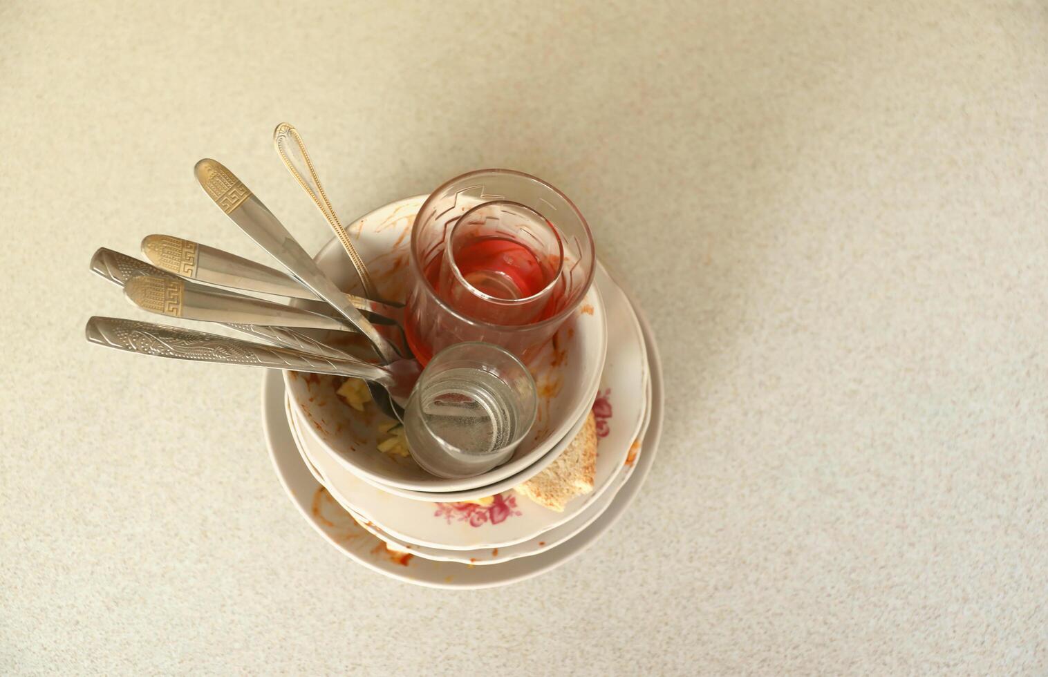 pilha de pratos sujos com restos de comida na mesa após a refeição. conceito de final de banquete. pratos sujos foto