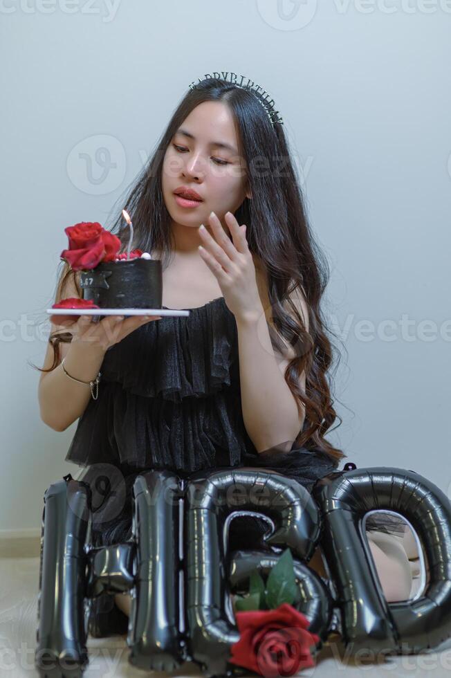 lindo mulher vestindo uma Preto vestir e chocolate bolo dentro a conceito do aniversário foto