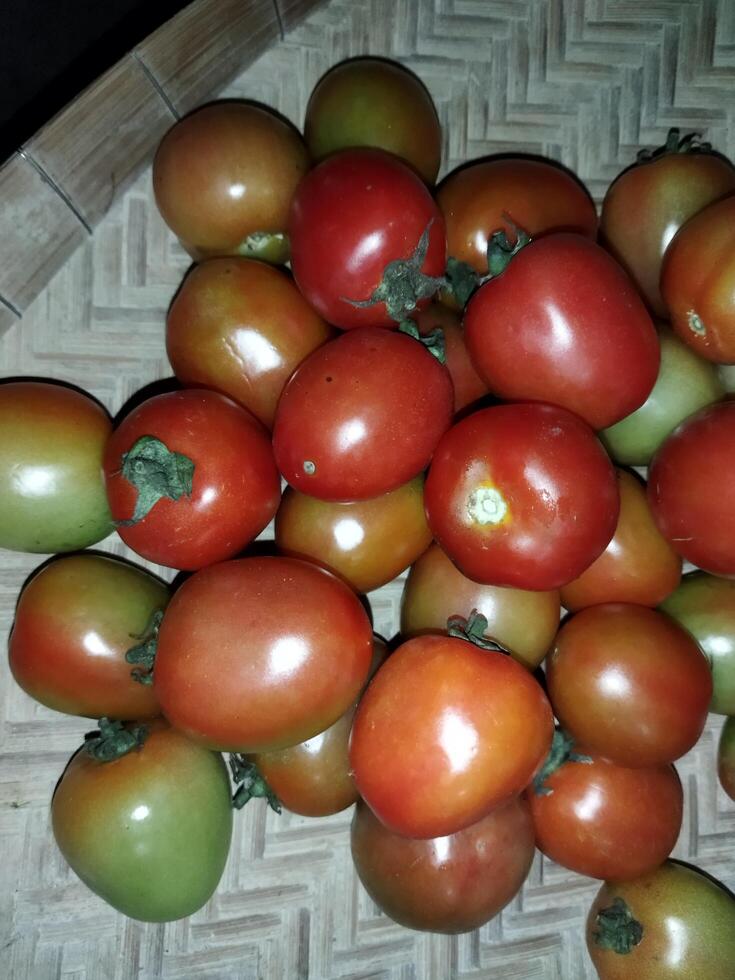 uma pilha do tomates com verde e vermelho fruta foto