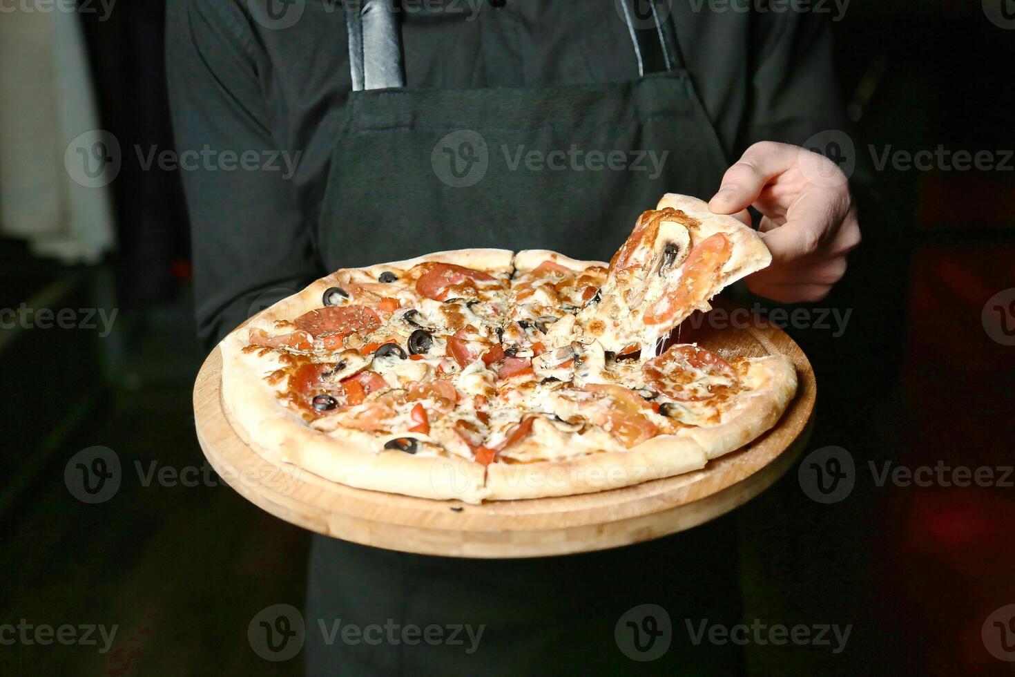 pessoa segurando pizza em de madeira prato foto