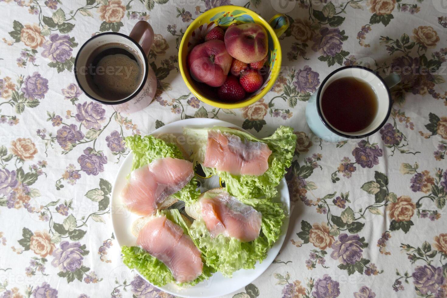 a sanduíches com salmão, frutas e bebidas em uma cozinha mesa. saboroso café da manhã. foto