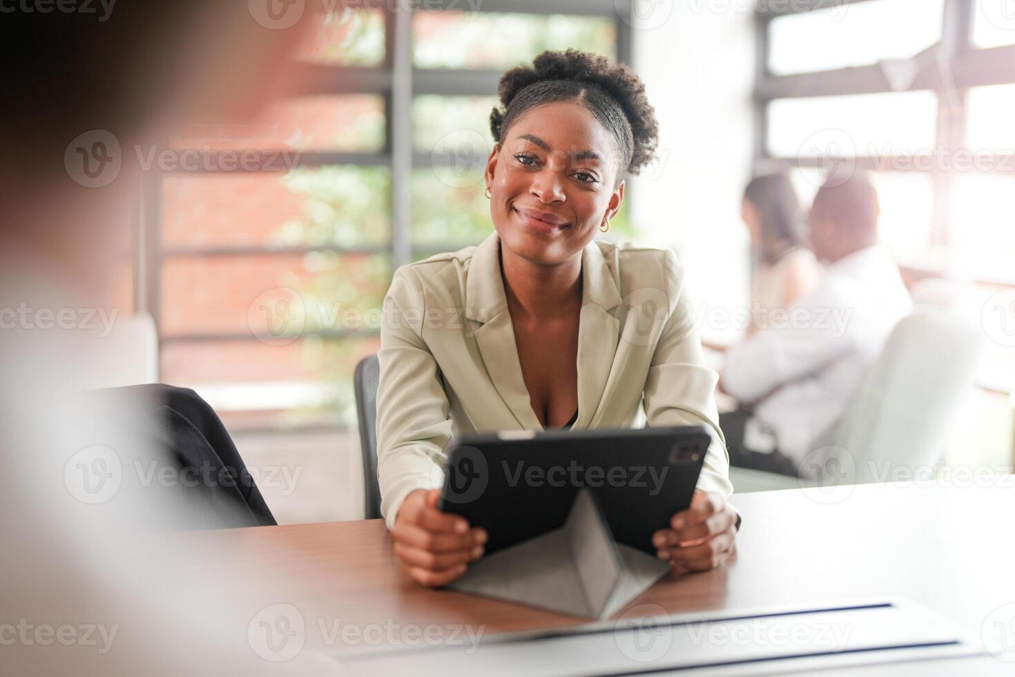 africano Preto o negócio mulher usando Smartphone enquanto trabalhando em computador portátil às escritório. sorridente maduro africano americano empresária olhando acima enquanto trabalhando em telefone. bem sucedido mulher empreendedor. foto