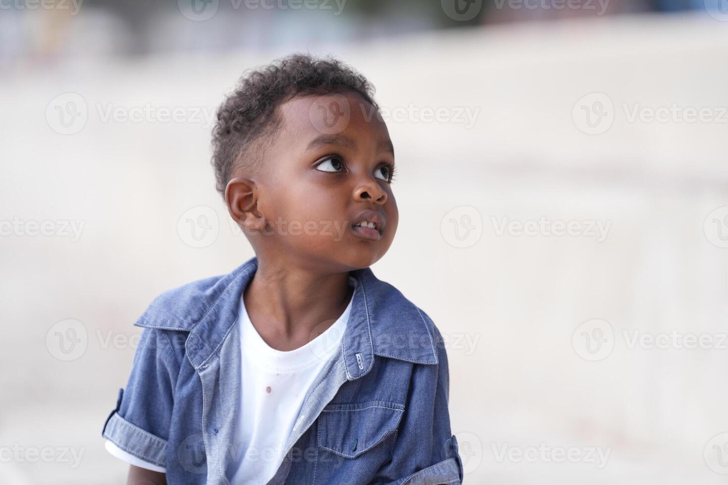 misturado raça africano e ásia Garoto é jogando às a ao ar livre área. sorridente feliz Garoto tem Diversão corrida em a de praia. retrato do Garoto estilo de vida com uma único Penteado. foto