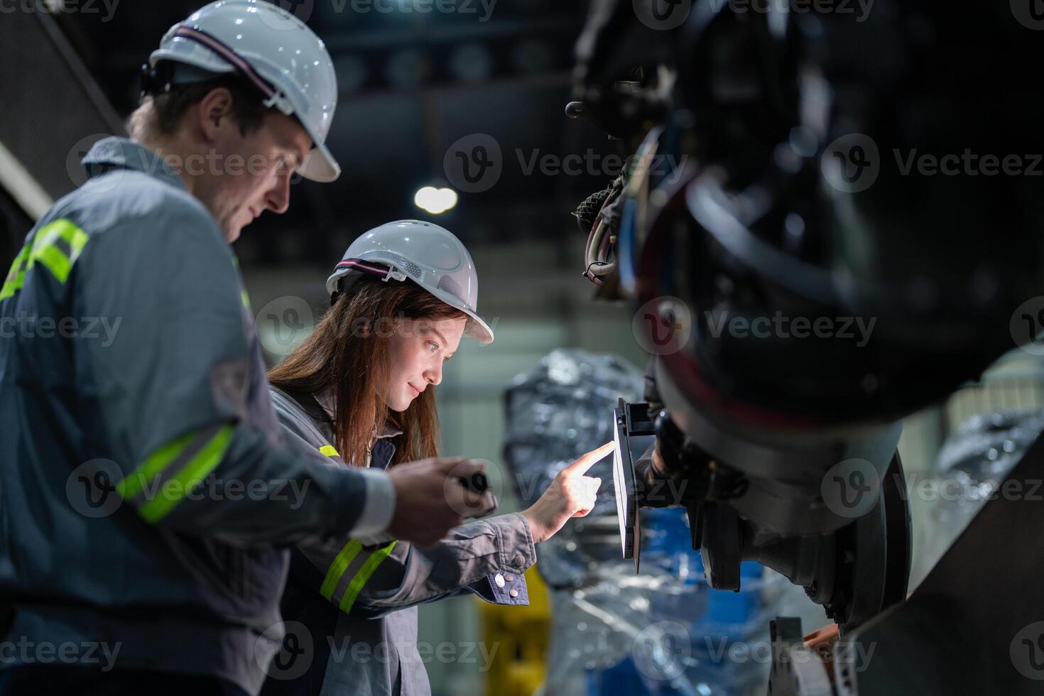 engenheiros Verifica ao controle pesado máquina robô braço. diverso equipe do industrial robótica engenheiros colhido por aí máquina. profissional maquinaria operadores reparar elétrico robô em brilhante digital painel. foto