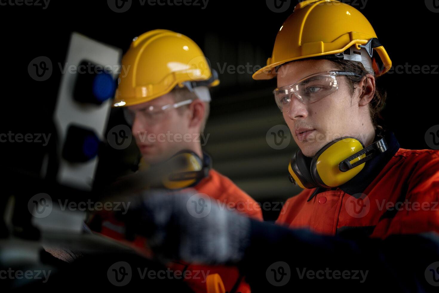 engenheiro homem verificação a status do máquina e usava chave inglesa para parafuso alguns parte do equipamento às cnc fábrica. trabalhador vestindo segurança óculos e capacete. manutenção e reparação conceito. foto