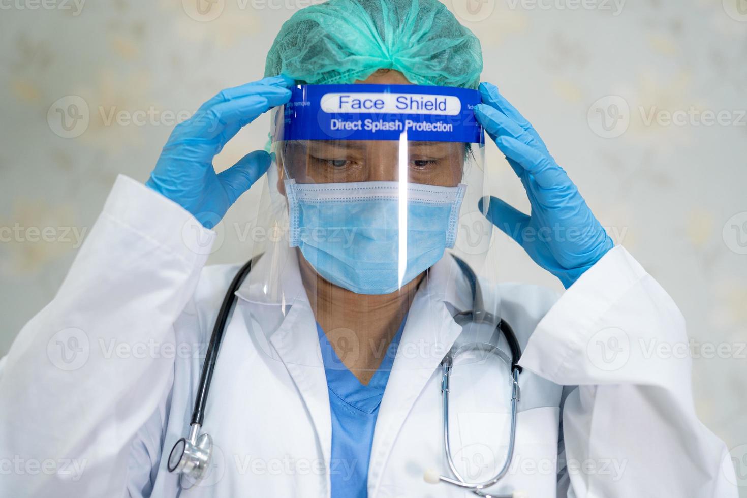 médico asiático usando protetor facial e terno novo normal para verificar o paciente protege a segurança infecção covid-19 surto de coronavírus na enfermaria de quarentena do hospital. foto