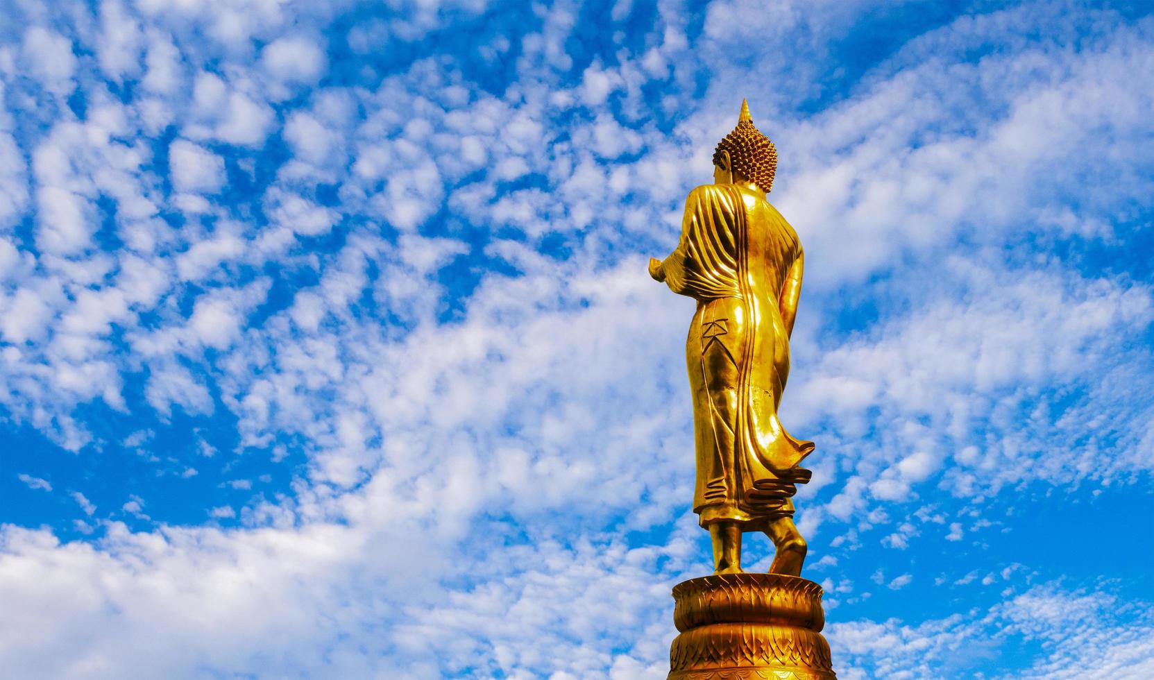 estátua de Buda dourado no fundo do céu azul crença do budismo foto