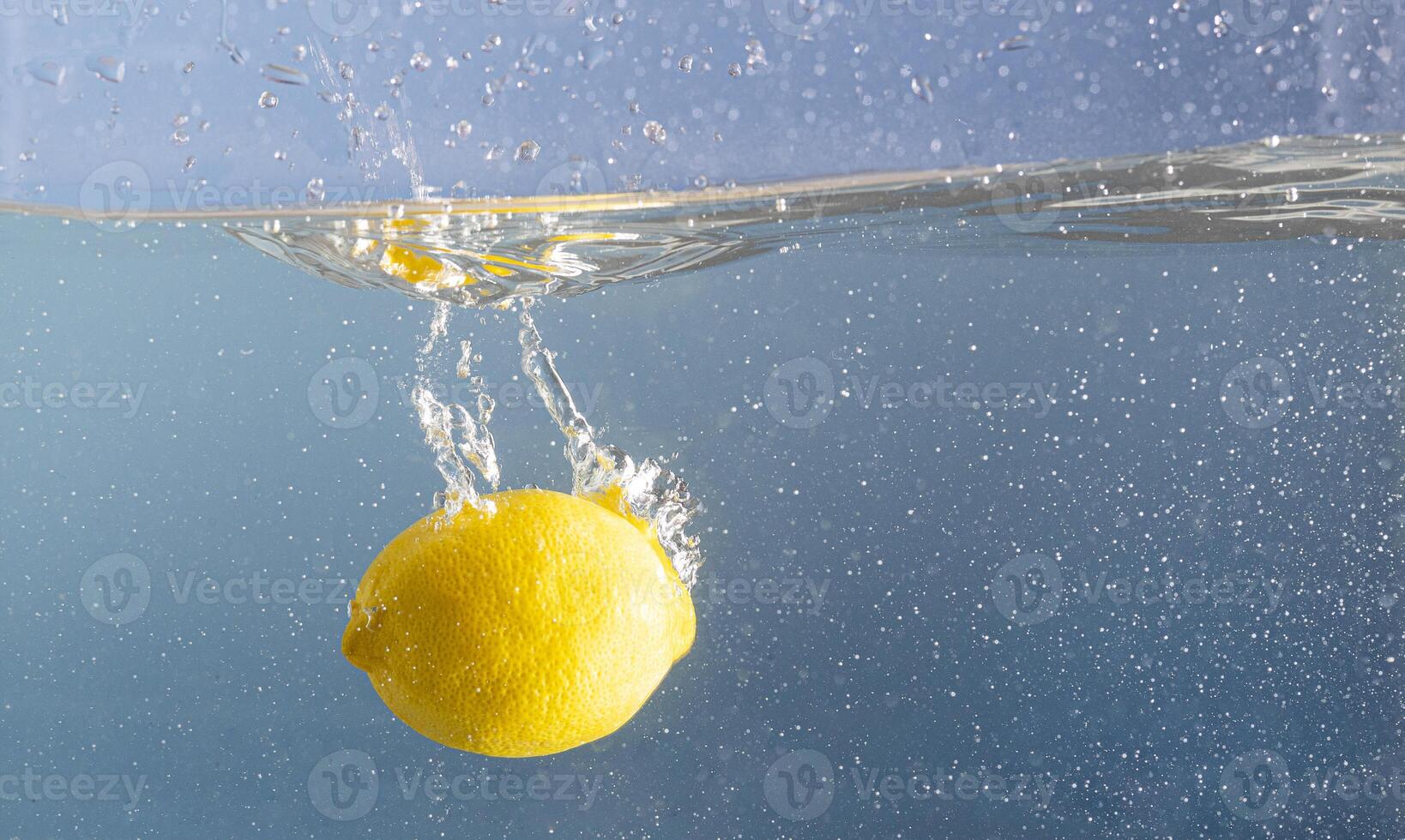 fresco limão encharcado profundo para dentro a espirrando azul água. azul piscina água e uma fruta movimento. criativo verão Comida conceito. foto