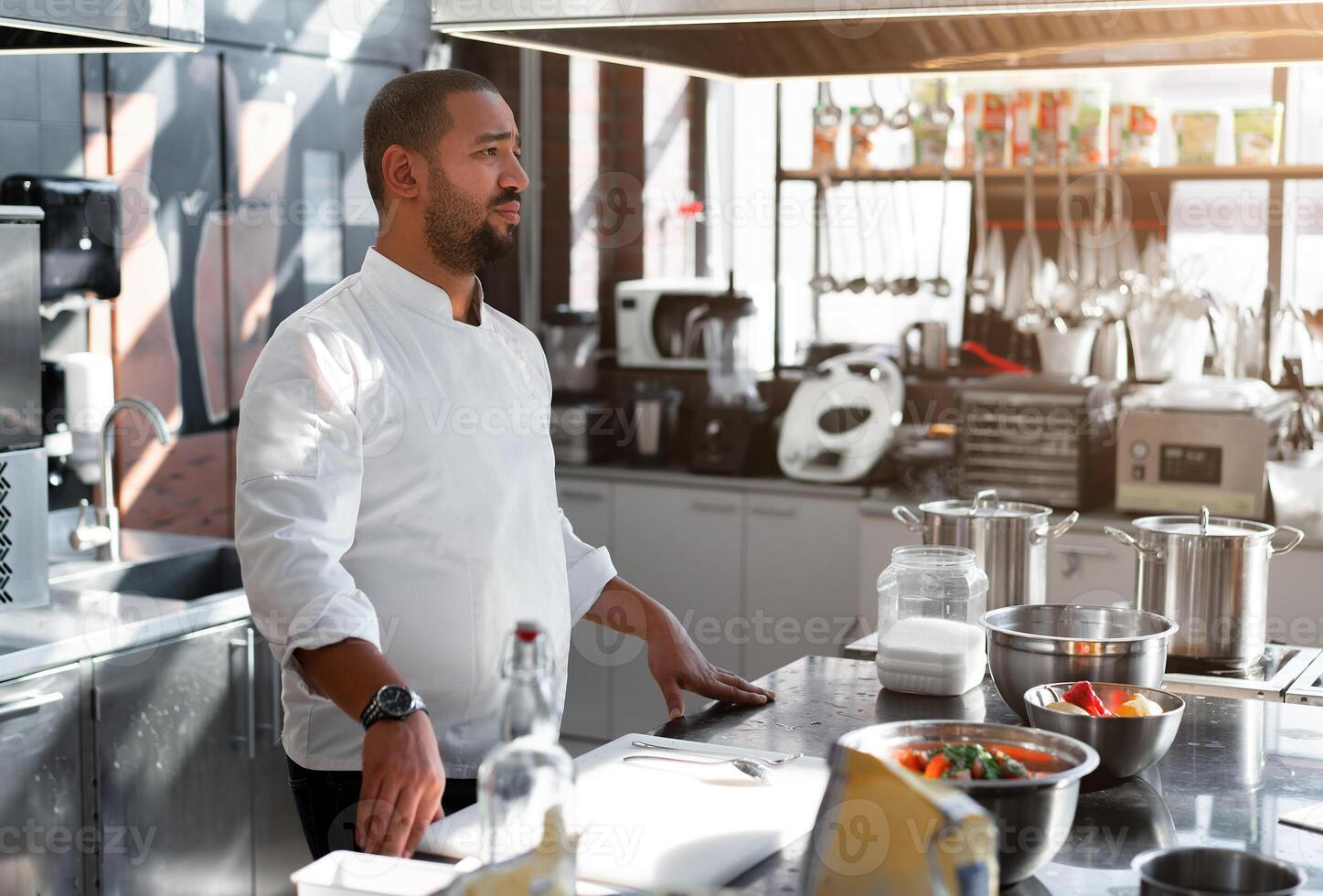 a chefe de cozinha condutas uma mestre classe dentro culinária. em a fundo é cozinha utensílios, em a mesa dentro frente do ele legumes dentro taças foto