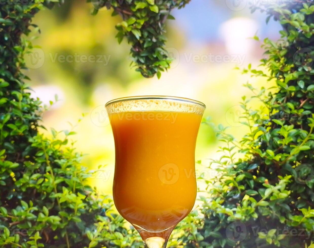 laranja suco dentro Barra vidro dentro frente do folhas coração forma- fruta beber dentro a vidro - coquetel foto