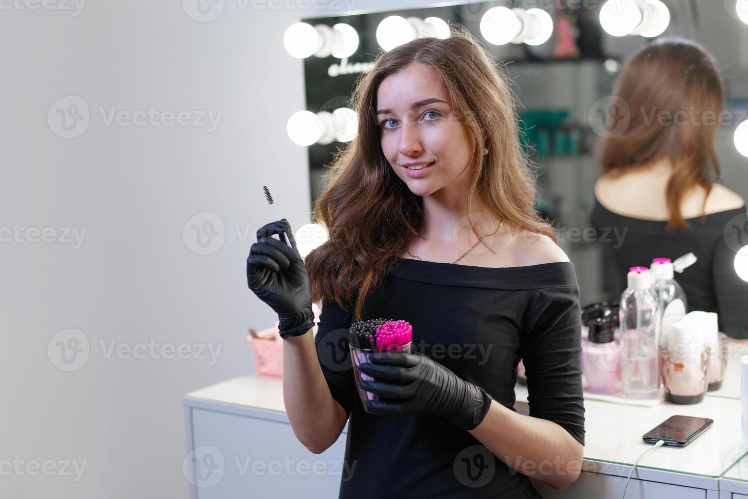 lindo jovem caucasiano Maquiagem artista em pé com ferramenta dentro mãos em fundo espelho dentro uma beleza salão. foto