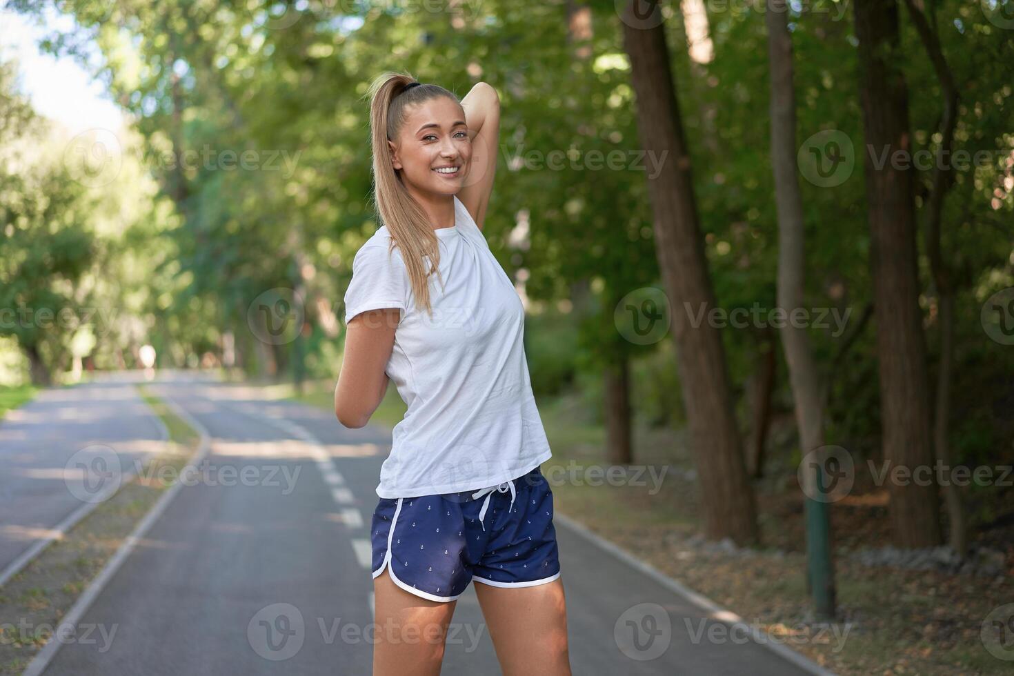 mulher corredor alongamento braços antes exercício verão parque manhã foto