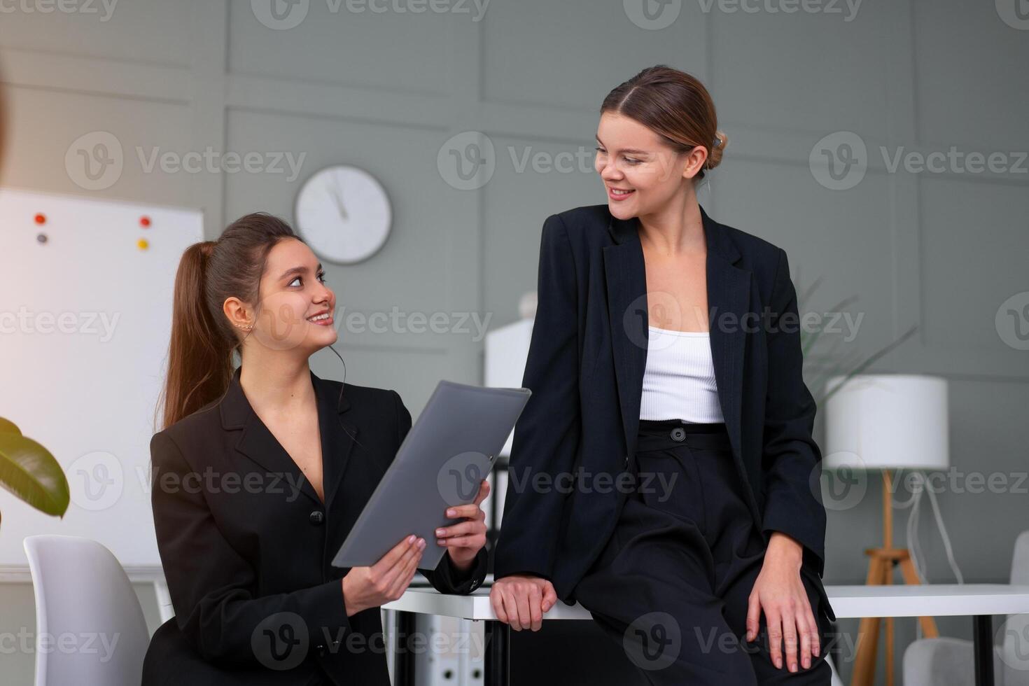 jovem mulheres líderes estão verificação financeiro afirmações a partir de papel documentos. dois fêmea confiante o negócio trabalhador vestido Preto terno dentro escritório verificação financeiro documento foto