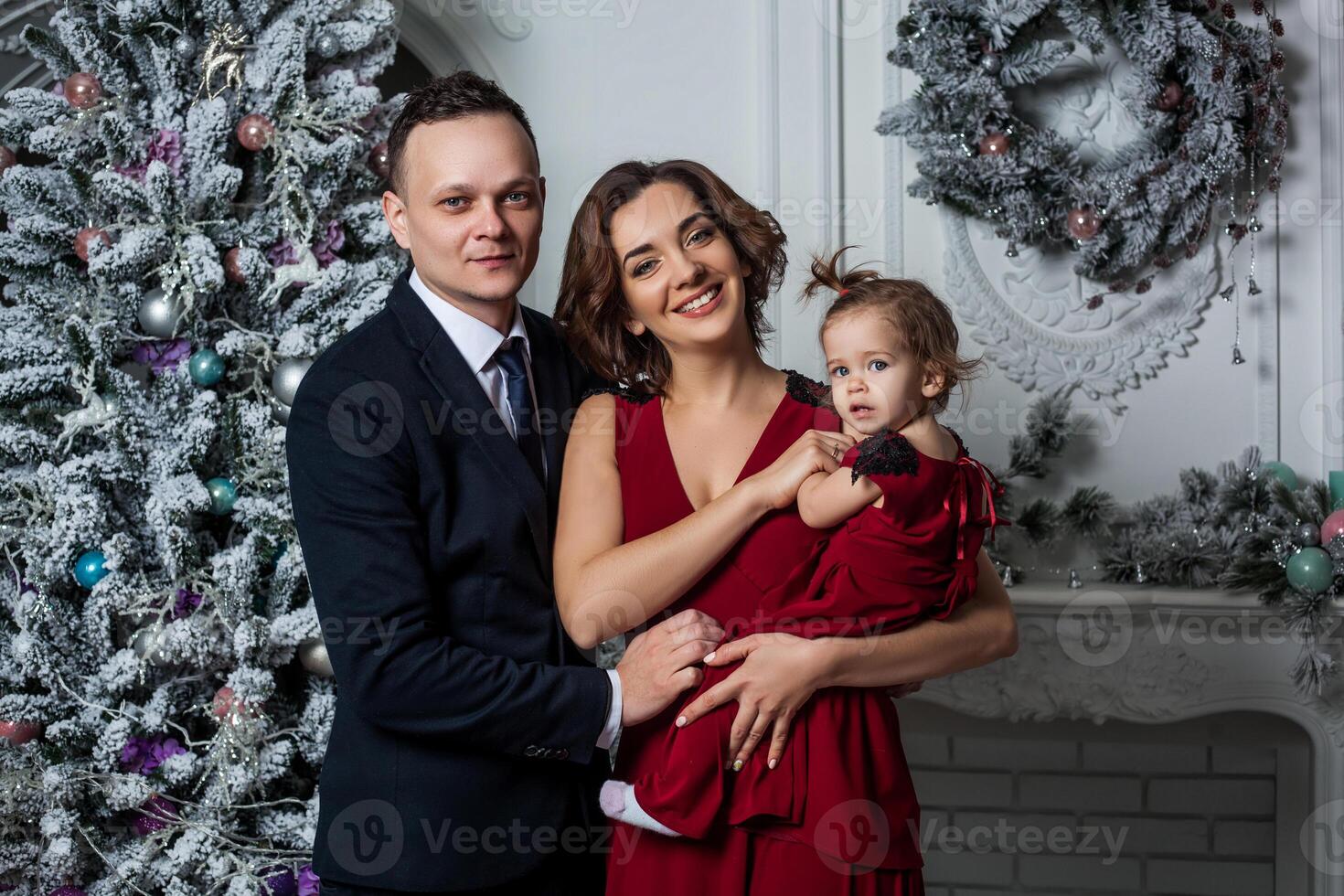 mãe Papai e filha vestido dentro uma à moda terno e elegante vermelho tarde vestir às uma secular festa dentro honra do a Novo ano foto
