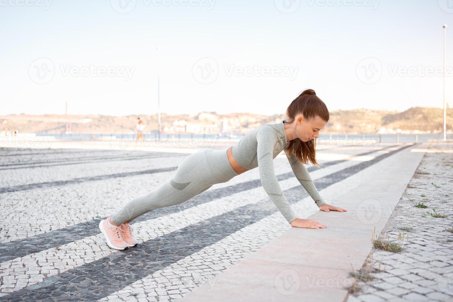 cheio comprimento, Forte em forma menina roupa de esporte Treinamento prancha ao ar livre foto