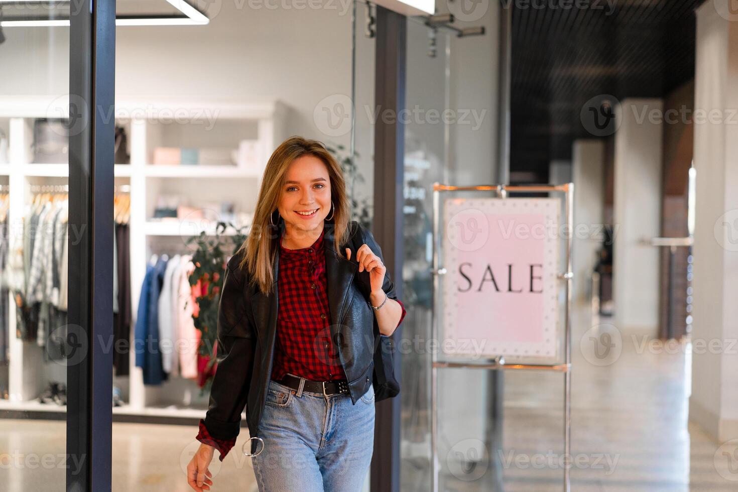 jovem lindo menina vai Fora roupas loja com compras. estação venda feliz jovem adulto fêmea foto