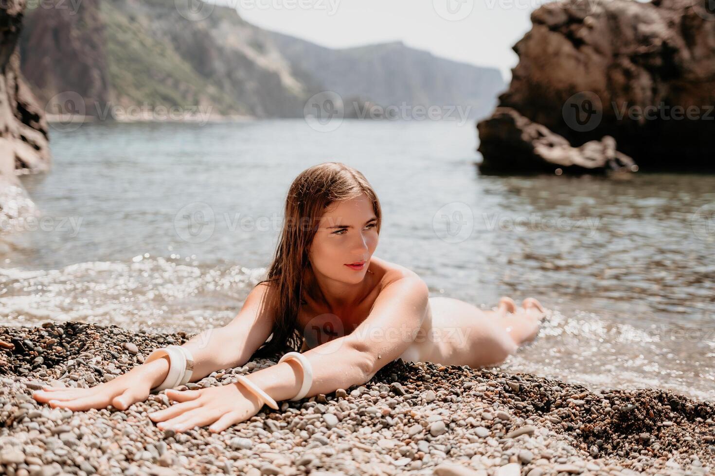 mulher viagem mar. feliz turista dentro chapéu apreciar levando cenário ao ar livre para recordações. mulher viajante posando em a de praia às mar cercado de vulcânico montanhas, partilha viagem aventura viagem foto