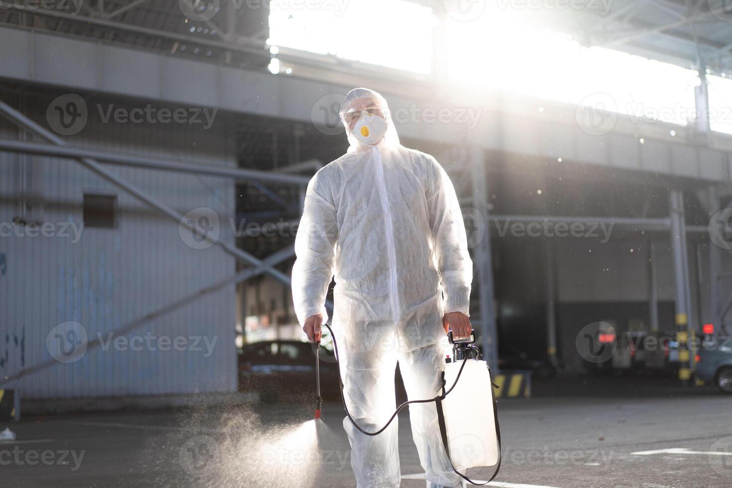 homem vestido branco protetora macacão pulverização superfície antibacteriano desinfetante pulverizador durante quarentena foto