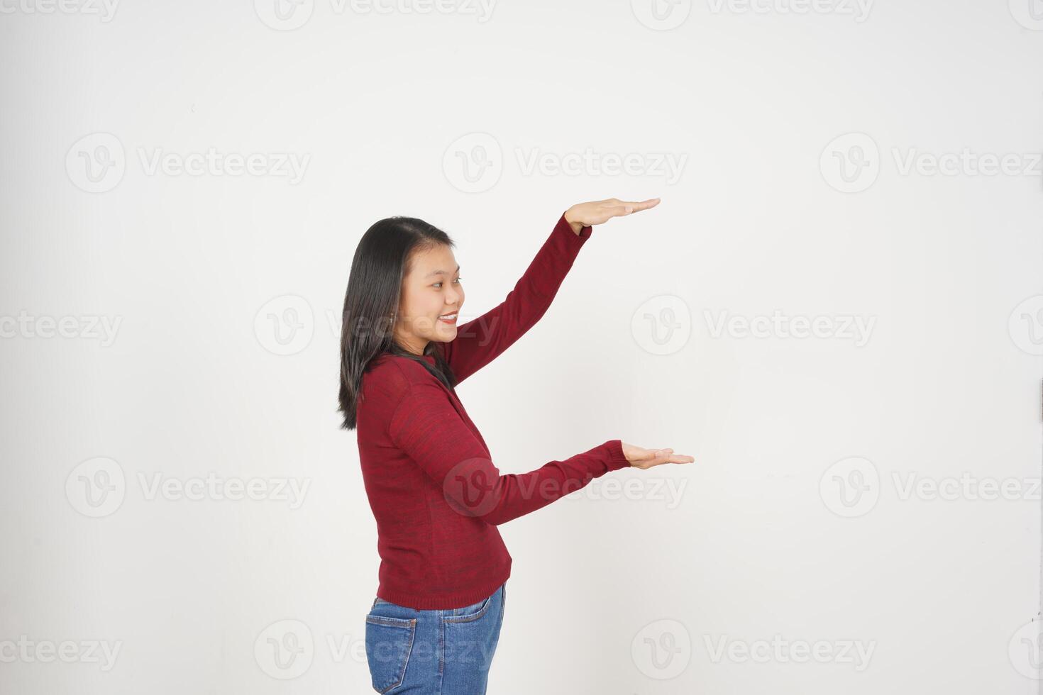 jovem ásia mulher dentro vermelho camiseta medindo e segurando grande produtos isolado em branco fundo foto