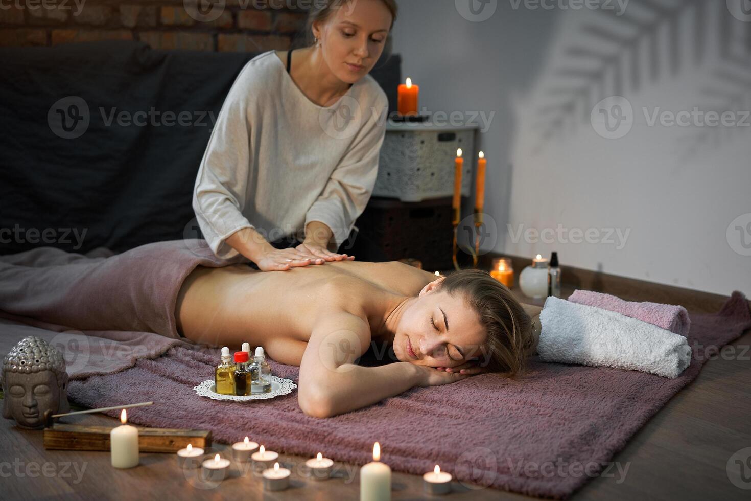 relaxar e apreciar dentro spa salão, obtendo massagem de profissional massagista. mulher deitado com nu costas relaxar em chão cobertor foto