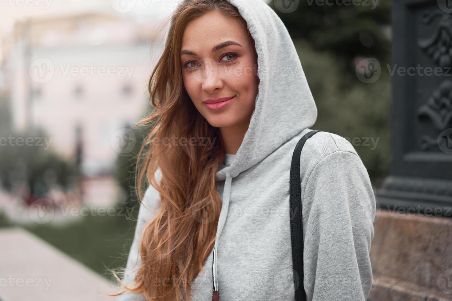 sorridente mulher cinzento moletom com capuz verão rua dia cidade vida moderno feliz urbano fêmea perder acima retrato foto