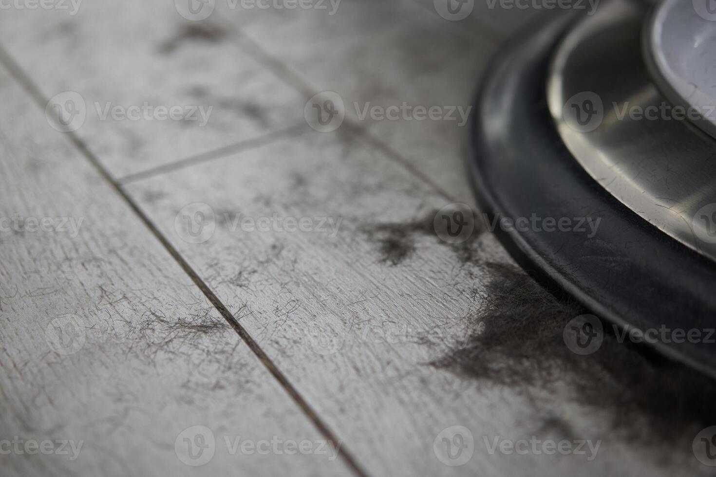 curto Preto masculino cabelo mentiras em a chão perto barbearia poltrona do a cabeleireiro depois de uma corte de cabelo. foto