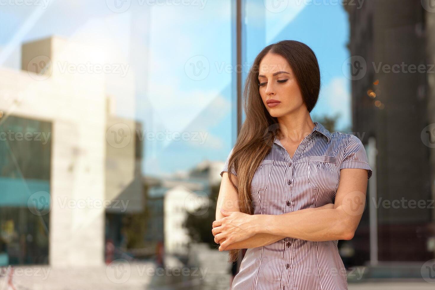 o negócio mulher 35 anos vestido listra camisa com grandes cabelo em pé perto escritório construção ao ar livre foto