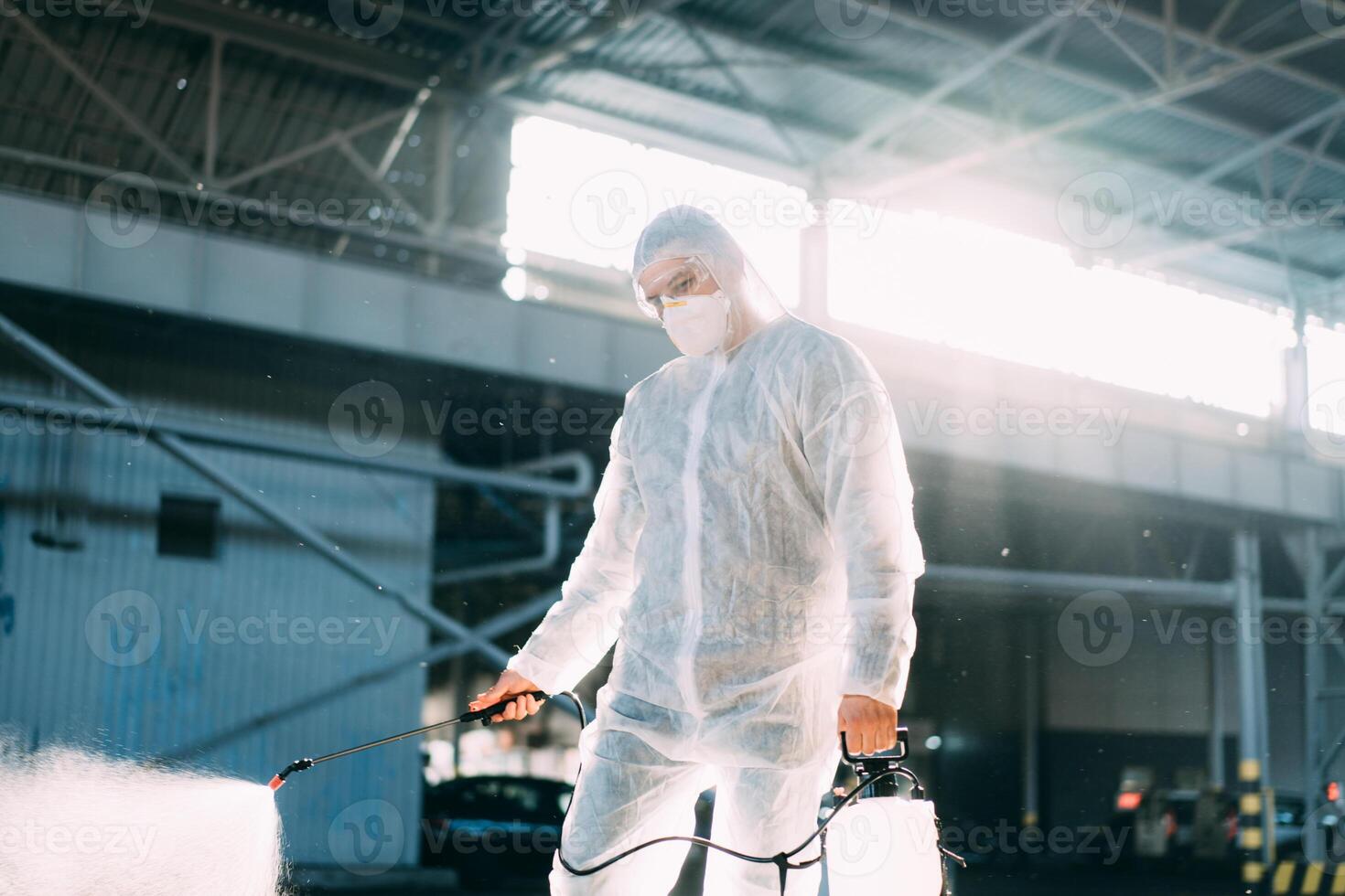 homem vestido branco protetora macacão pulverização superfície antibacteriano desinfetante pulverizador durante quarentena foto