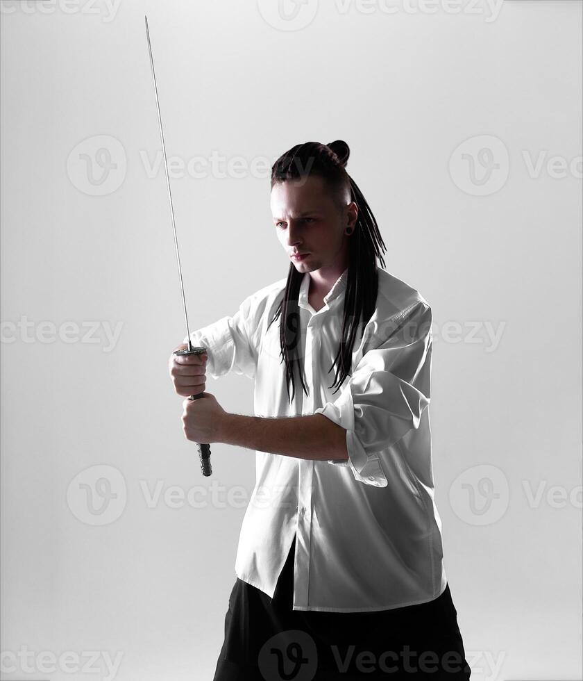 jovem homem segurando uma samurai espada. glamour foto. foto