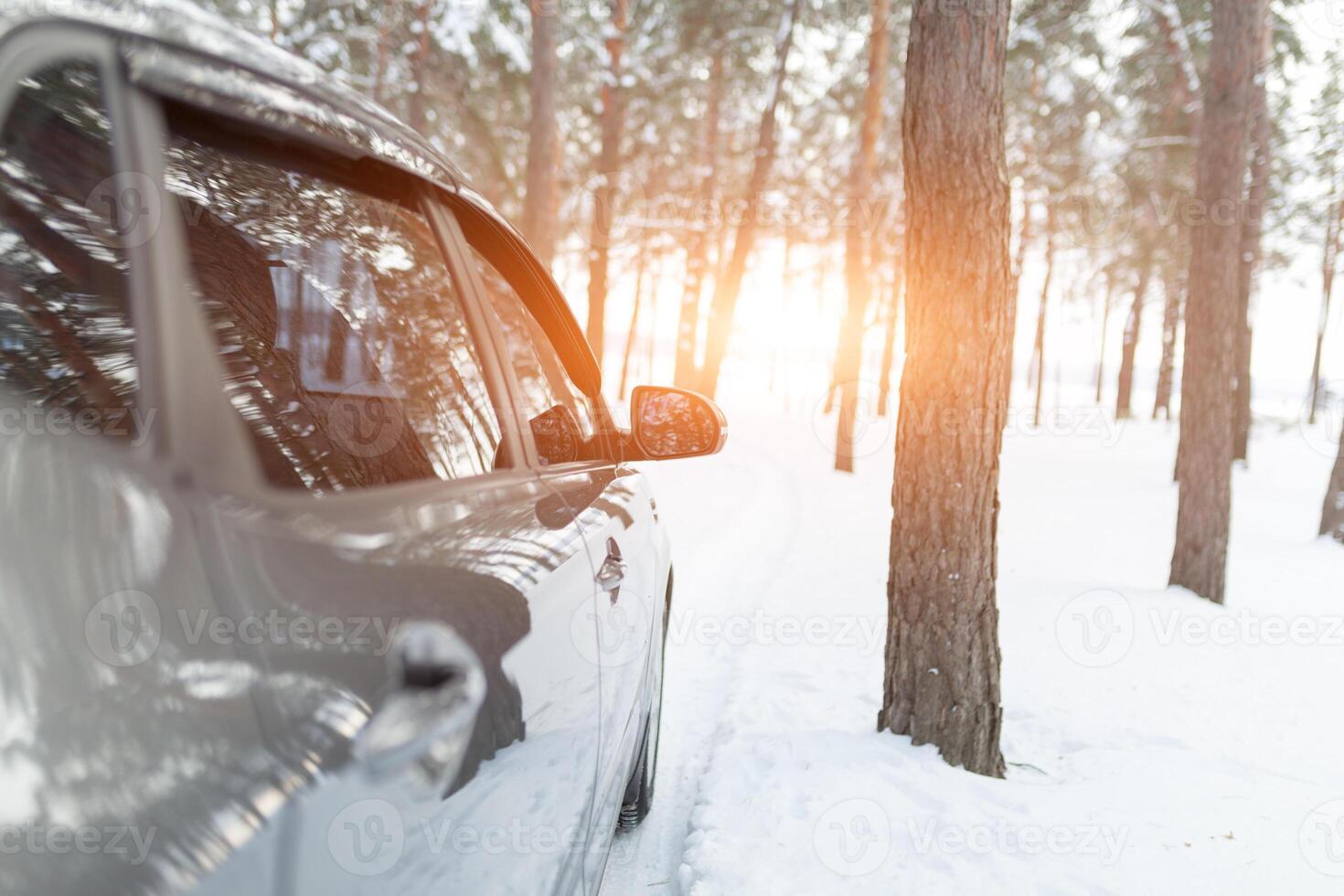 uma prateado carro dentro uma Nevado inverno floresta estrada foto