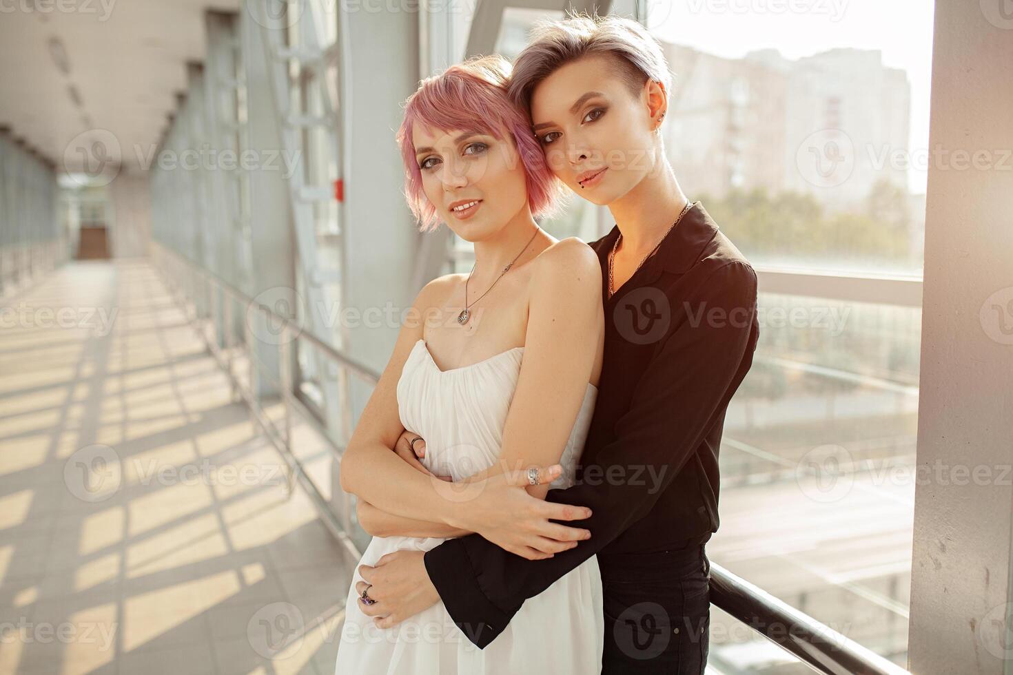 pessoas, homossexualidade, mesmo sexo casado, viagem e gay amor conceito - fechar acima do feliz mulheres casal abraçando sobre metall ponte. dois namorada andando. foto