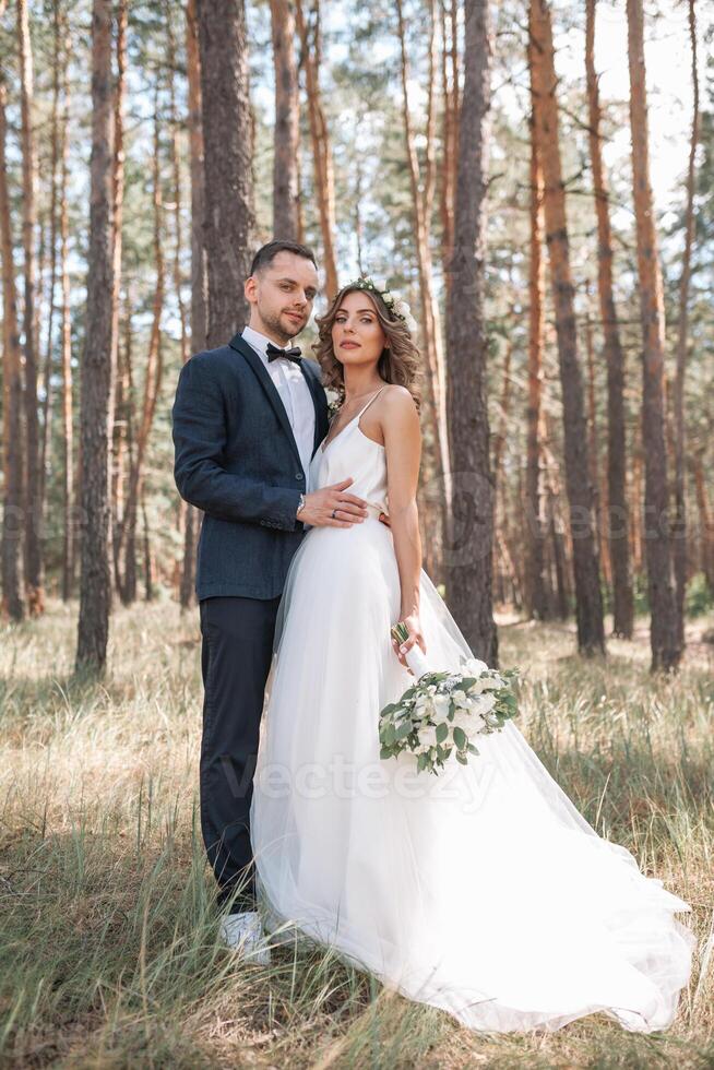 noiva e noivo às Casamento dia caminhando ao ar livre em verão natureza. nupcial casal, feliz recém-casado mulher e homem abraçando dentro verde parque. amoroso Casamento casal ar livre. noiva e noivo foto