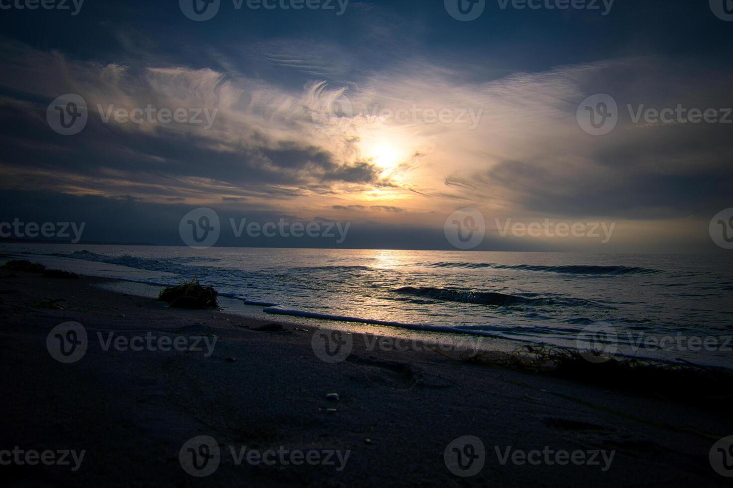 pôr do sol, iluminado mar. arenoso de praia dentro a primeiro plano. luz ondas. báltico mar foto