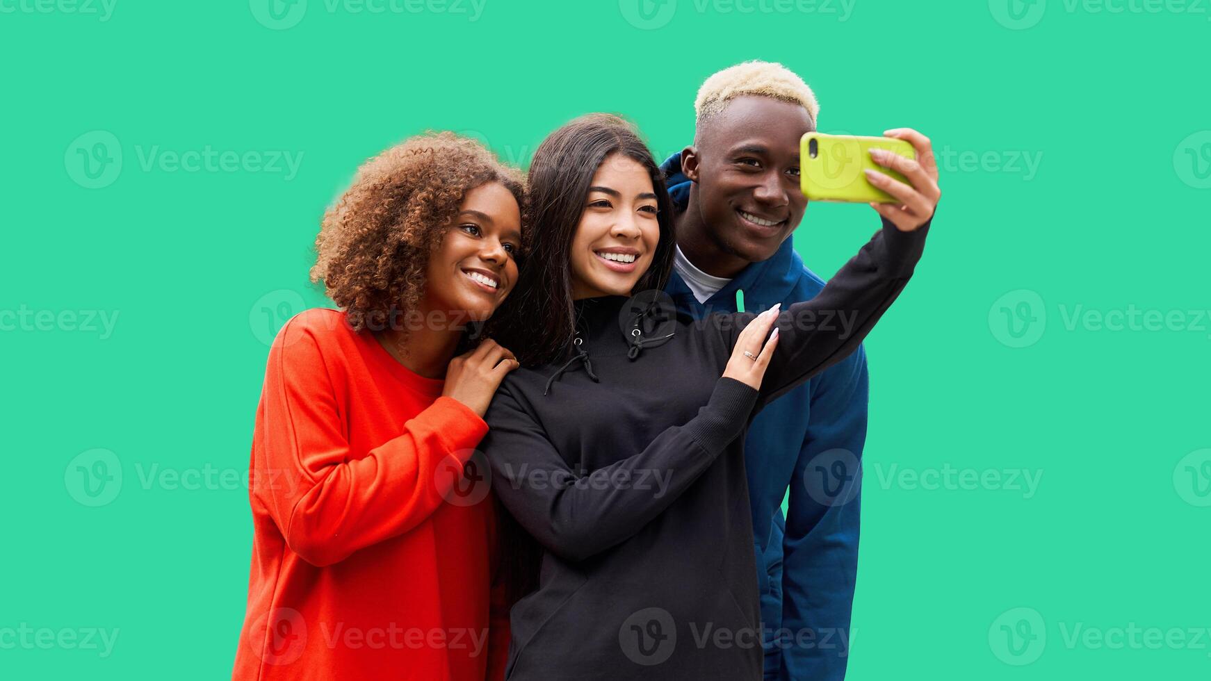 estúdio tiro do agradável jovem multicultural amigos. lindo pessoas alegremente sorridente e tendo Diversão enquanto fazer selfie foto. isolado verde fundo foto