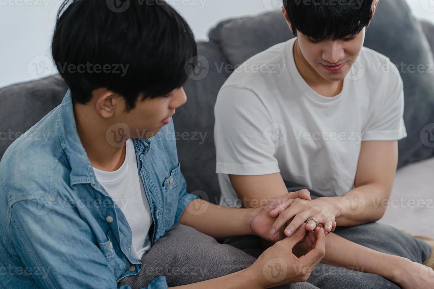 jovem casal gay asiático propor em casa, adolescentes coreanos lgbtq homens felizes sorrindo têm um tempo romântico ao propor e casamento surpresa usar anel de casamento na sala de estar no conceito de casa. foto
